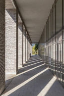 Au rez-de-chaussée, une colonnade est aménagée pour permettre l’accès latéral. (Photo: Steve Troes)
