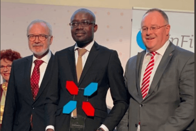L’award de la microfinance remis à Albert Sié Dah, représentant d’Advans Côte d’Ivoire, par le président de la BEI, Werner Hoyer, et le ministre luxembourgeois de la Coopération, Romain Schneider. (Photo: Twitter/E-MFP)