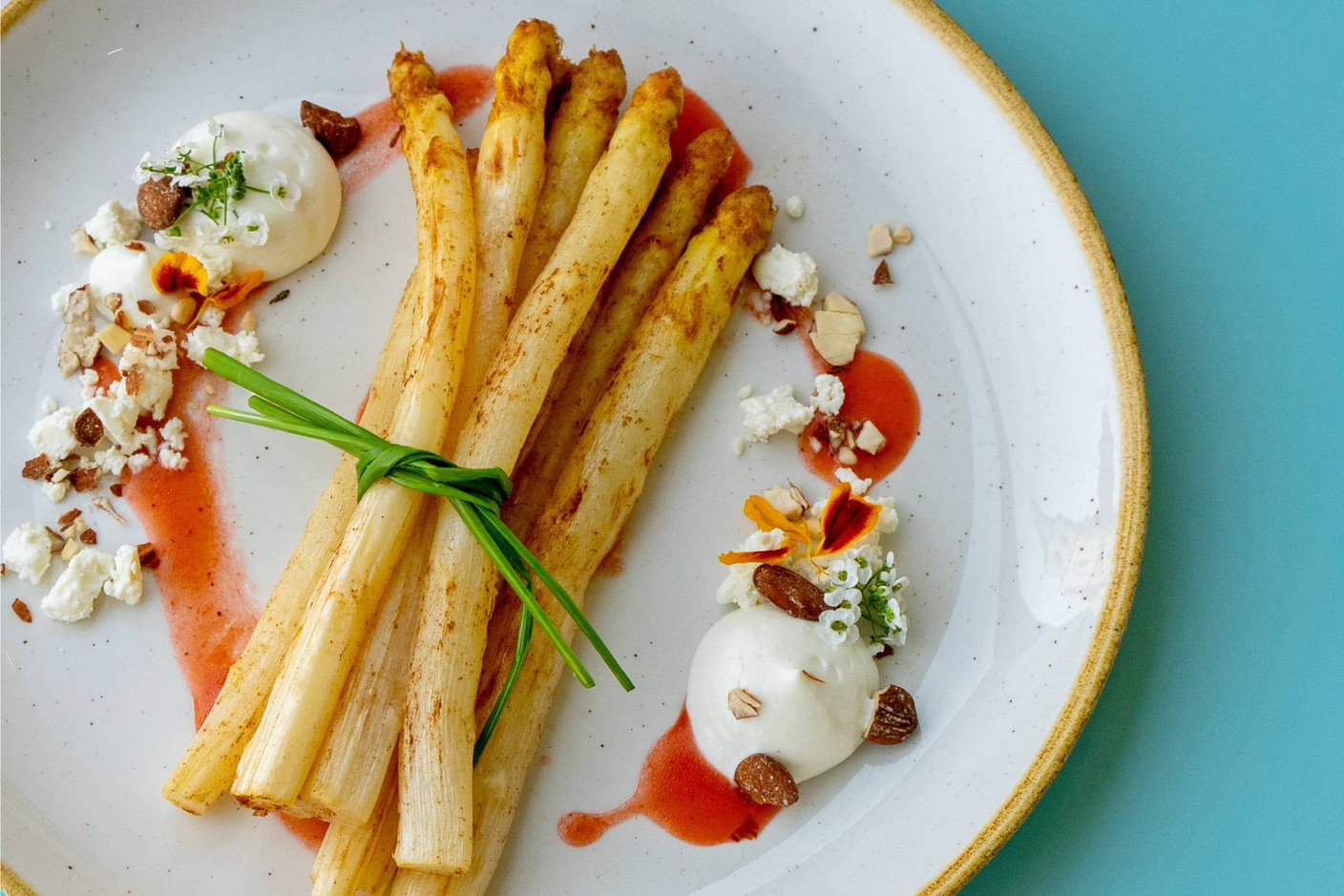Asperges blanches, accompagnées de vinaigrette aux fraises, mousse de féta et amandes grillées. (Photo: B13)