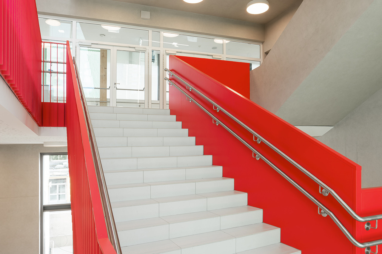 Un escalier au garde-corps rouge vif dessert les étages.  (Photo: Julien Swol)