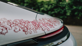 The painters applied a delicate flaming red lion motif by hand to the glacier grey metallic paint, requiring more than 20 production steps. This motif adorns the bonnet, wings, doors, side panels, fuel filler cap, rear spoiler and roof of the 911 GT3. Photo: Porsche