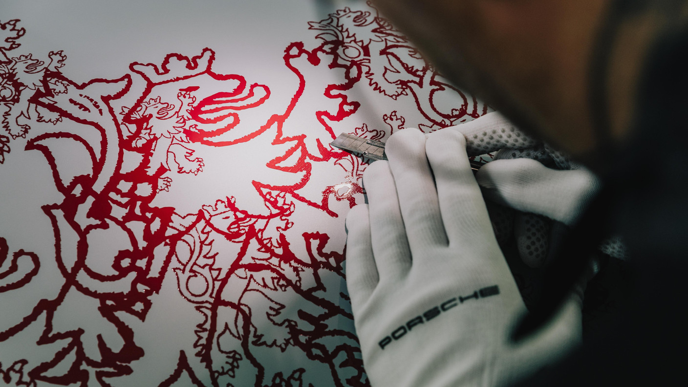 Painters applied a delicate flaming red lion motif by hand to the glacier grey metallic paint, requiring more than 20 production steps. This motif adorns the bonnet, wings, doors, side panels, fuel filler cap, rear spoiler and roof of the 911 GT3. Photo: Porsche