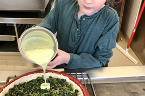 Louise, la fille du chef René Mathieu, nous apprend à faire sa tarte aux herbes sauvages préférée. Étape 5:  elle verse l’appareil sur les feuilles, avant de faire cuire le tout au four. (Photo: René Mathieu)