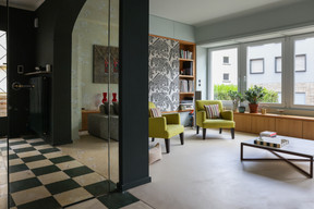 In the living room, the television is hidden by a panel covered in a graphic tapestry that adds character and warmth to the space. Photo: Marie Russillo/Maison Moderne