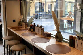 Une assise haute a été positionnée le long de la vitrine et est complétée par quelques tables dans le fond de la salle. (Photo: Paperjam.lu)