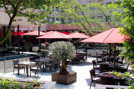 Un extérieur à la fois vert et urbain, proche du parc et du centre-ville, où il fait bon déguster quelques bons petits plats: voilà pourquoi terrasse et palace font bon ménage à l’Amélys! (Photo: Hôtel Le Royal)