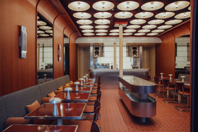 The brushed stainless steel bar, the retro-futuristic heart of the Café de Paris: visible from the Place d’Armes, it sets the tone from the moment you walk in. (Photo: Sebastien Madlener)