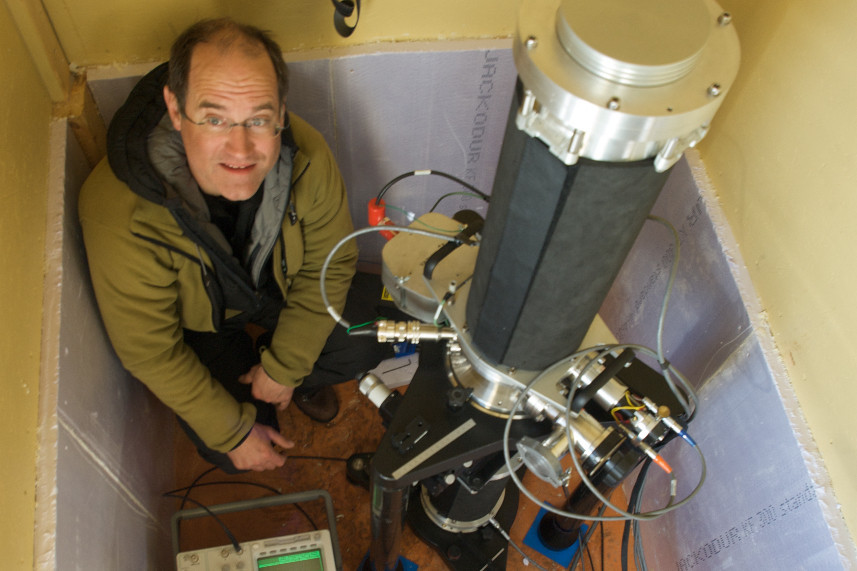 Dr Francis poses with one of his gravimeters, which is housed in a little hut in Antarctica. Photo: Olivier Francis