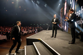 Christophe Goossens, on left, takes to stage after a lively introduction by jury member Georges Krombach (centre) at the Paperjam Top 100 ceremony, 10 December 2024. Photo: Nader Ghavami / Maison Moderne