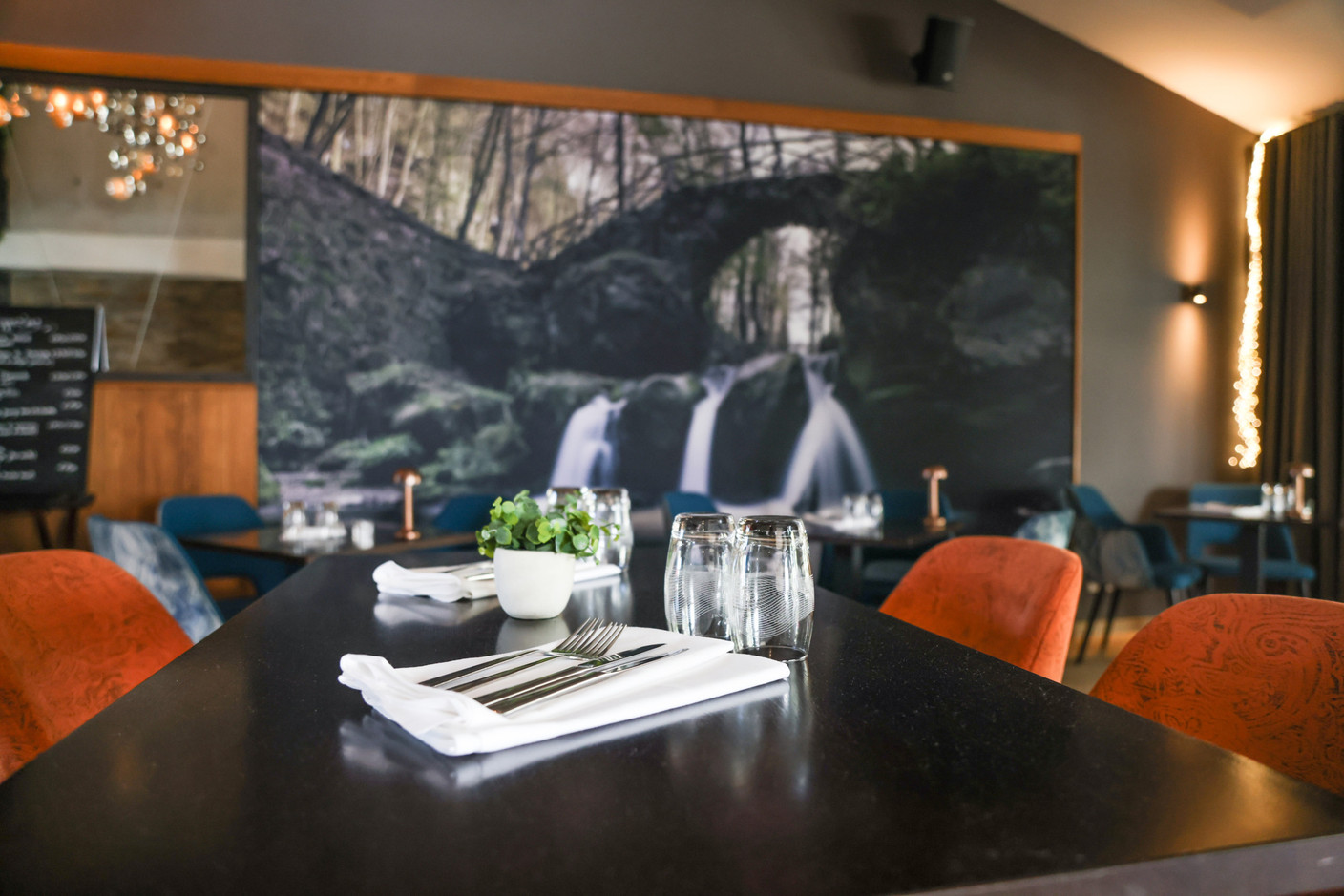 If the chandeliers and the huge photo of the Mullerthal waterfall make a memorable impression, so too does the gargantuan glass wine cellar that forms the dining room’s centrepiece. Eva Krins Maison Moderne
