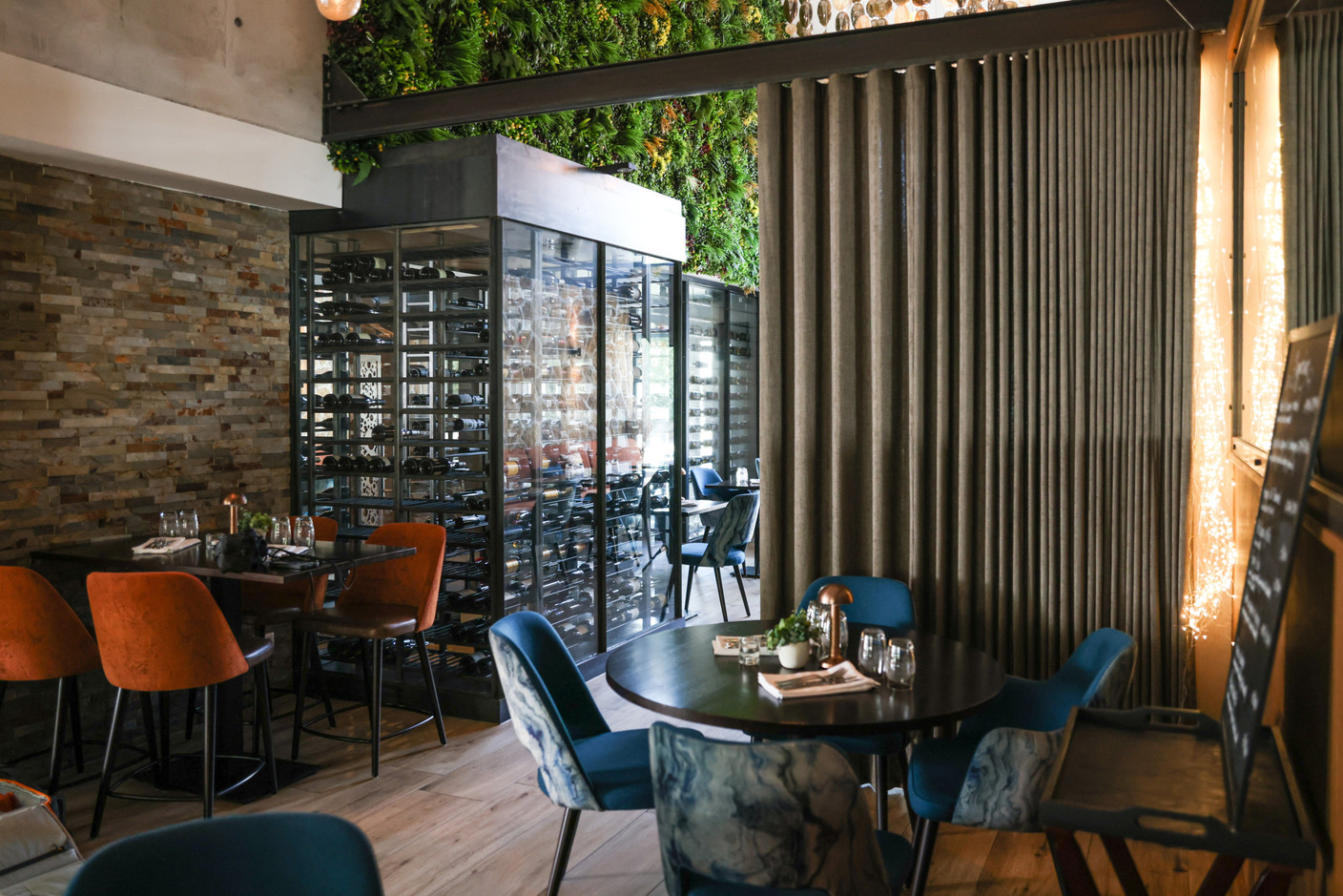 If the chandeliers and the huge photo of the Mullerthal waterfall make a memorable impression, so too does the gargantuan glass wine cellar that forms the dining room’s centrepiece. Eva Krins Maison Moderne