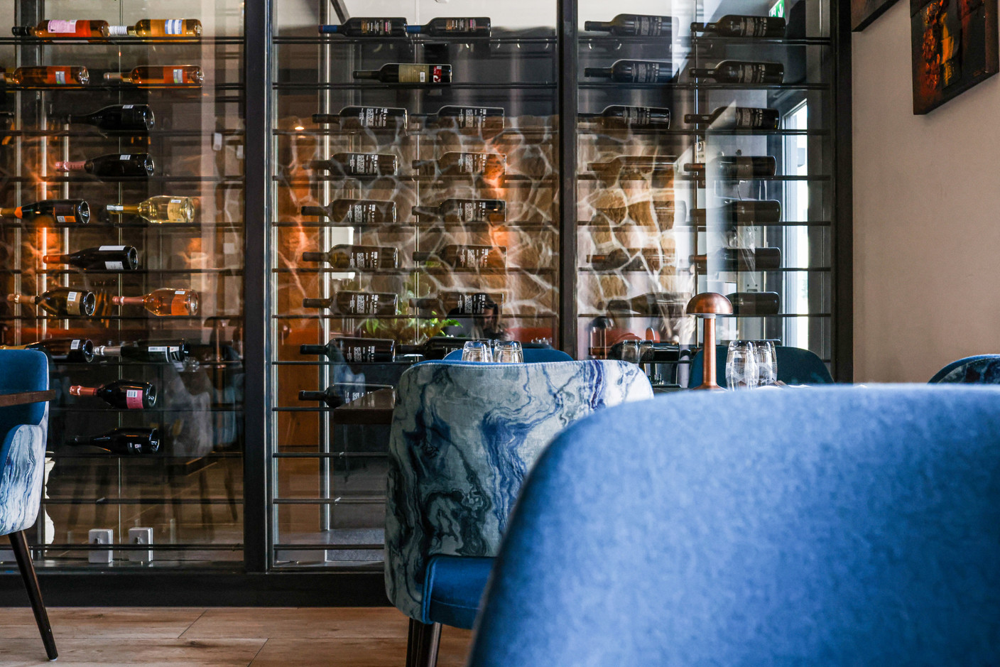 If the chandeliers and the huge photo of the Mullerthal waterfall make a memorable impression, so too does the gargantuan glass wine cellar that forms the dining room’s centrepiece. Eva Krins Maison Moderne