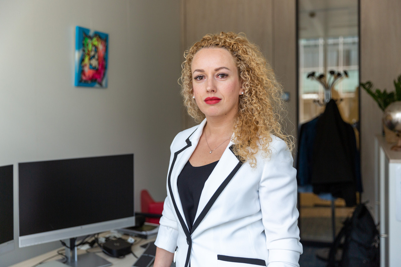 Irina Stoliarova, a funds lawyer with GSK Stockmann. A painting by Thomas Iser, that she bought following an exhibition hosted by GSK Stockmann, can be seen in the background, on the wall to the left. Photo: Romain Gamba
