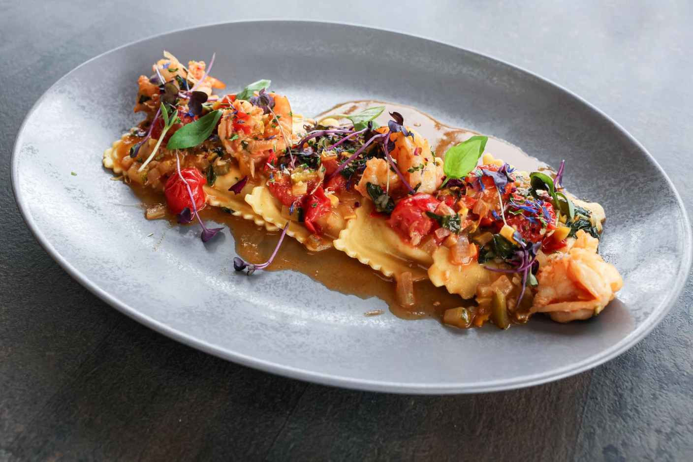 The raviolacci al crostacei with its stuffing of scampi, prawns, white fish and ricotta, accompanied by lobster bisque, cherry tomatoes, basil, white wine and vegetable salpicon. Marie Russillo (Maison Moderne)