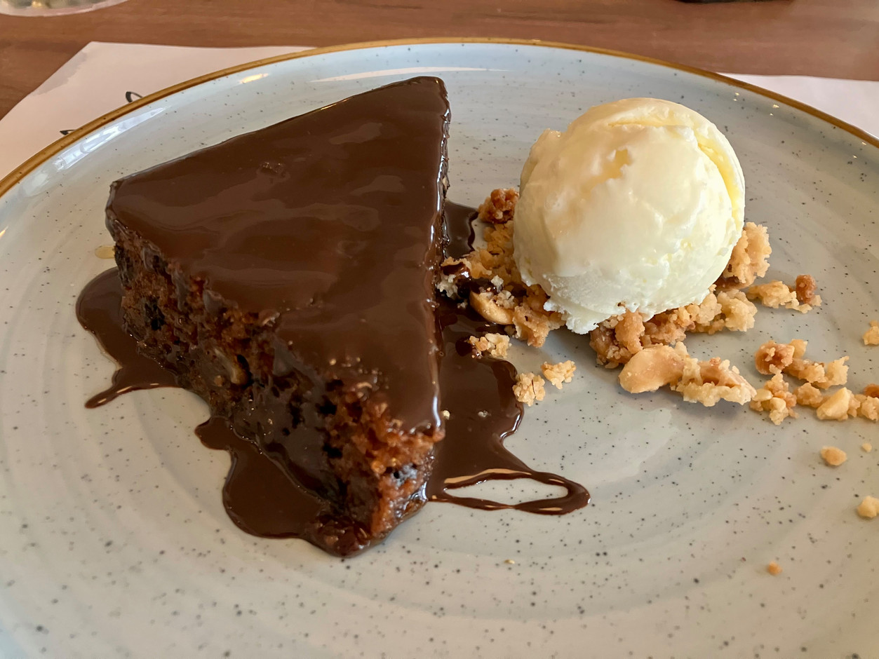 Karidopita, a traditional Greek walnut cake imbibed with syrup and cardamom, served with chocolate sauce, vanilla ice cream and hazelnut granola. Photo: Lydia Linna/Maison Moderne