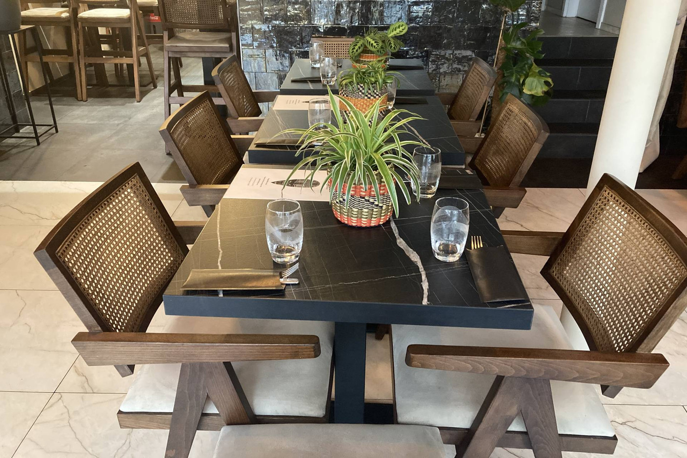Small bistro tables, green plants and wooden seats create an atmosphere that is both authentic and warm. Photo: Céline Coubray/Maison Moderne