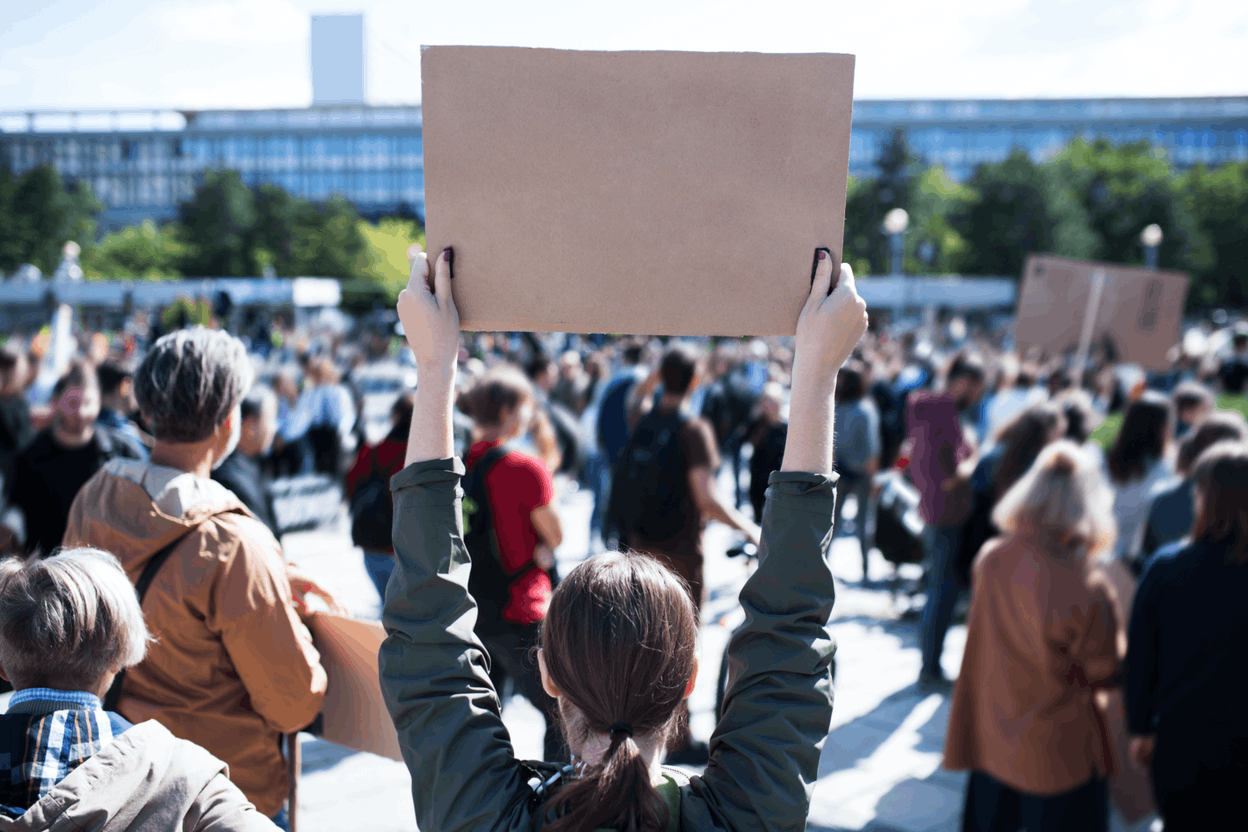 Protesters holding up signs and posters. (Photo: Halfpoint / Adobe Stock)