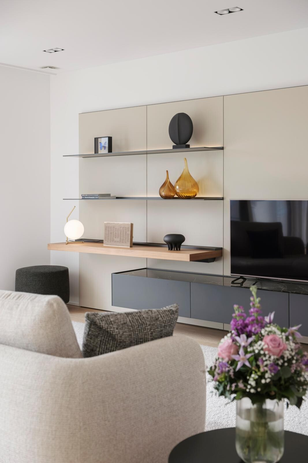 Integrated into the shelves, recessed lighting diffuses a soft glow that highlights the displayed objects. (Photo: Jan Hanrion/Paperjam)