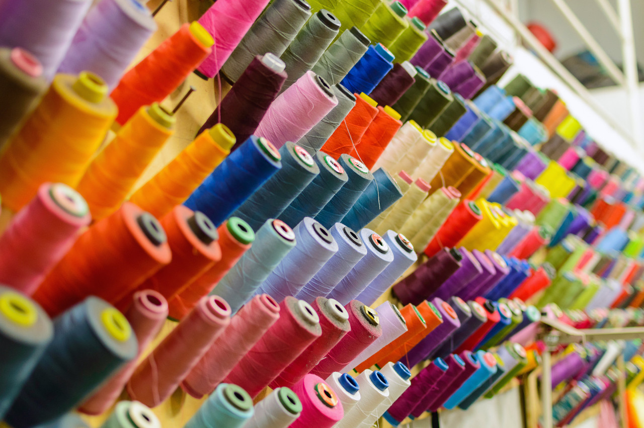 Colorful thread spools used in fabric and textile industry. The concept of sewing production. Copyright (c) 2017 Mikhail Gnatkovskiy/Shutterstock.  No use without permission.